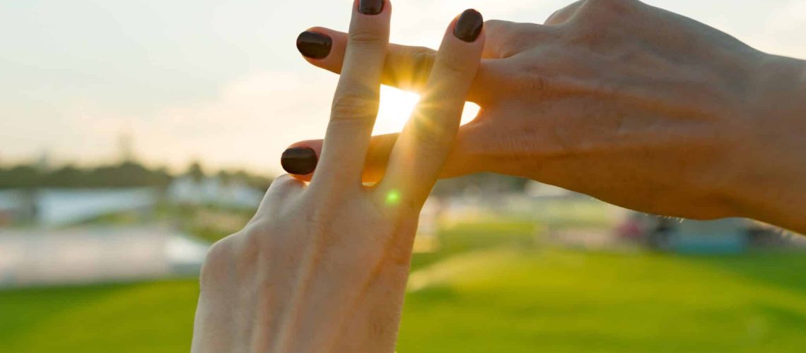 Hands show gesture symbol hashtag is viral, web, social media, network. Background is sunny urban sunset, concept for marketing, trending, blogging and internet themes